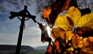 Ein hölzernes Kruzifix und herbstlich gefärbte Blätter, aufgenommen bei Kinding in Bayern. Ein Sturmtief sorgt in den kommenden Tagen für einen deutlichen Temperaturanstieg im Südwesten Deutschlands. Foto: ddp