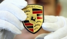 Ein Arbeiter montiert im Porsche-Stammwerk das Emblem an einem Fahrzeug. Die Erfolgsfahrt ist vorerst ausgebremst:Im agbelaufenen Geschäftsjahr ging der Absatz deutlich zurück. Foto: dpa