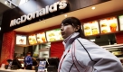 Olympische Winterspiele 2006, Dienstag (07.02.06), Turin: Eine japanische Athletin steht vor einer Filiale der Fast-Food-Kette Mc Donalds im Olympischen Dorf.
 Foto: ddp