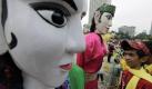 Ein Junge schaut sich in Jakarta, Indonesien, die riesige Puppen aus der Nähe an. Die traditionellen Puppen heißen ondel-ondel und sind Teil eines Festivals anlässlich des Nationalen Bildungstages des Landes. Foto: ap