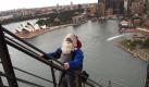 Was um alles in der Welt macht ein Weihnachtsmann zehn Tage vor dem Fest in unvollständiger Dienstkleidung auf der Hafenbrücke von Sydney? Sehr einfach: Es geht um den Titel 'Weihnachtsmann des Jahres'. Foto: AC Agency Foto: dpa