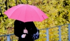 Eine Frau geht mit einem Schirm über eine Brücke in Freiburg. Der November startet zum Wochenbeginn grau in grau, zur Wochenmitte hin soll es auf den Bergen Schnee geben.
 Foto: ap