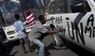Demonstranten schmieren in Haitis Hauptstadt Port-au-Prince Slogans gegen Präsident Rene Preval und die Vereinten Nationen auf ein UN-Auto. Sie protestieren gegen das Wahlergebnis aus dem vergangenen November. Foto: ap