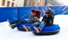 Besucher rutschen in Berlin auf Gummireifen die künstliche Rodelbahn der «Winterwelt am Potsdamer Platz» herunter. Am Samstag wurde die Winterwelt eröffnet, deren fester Bestandteil Europas größte mobile Rodelbahn sowie eine große Eisbahn am Marlene-Dietrich-Platz sind. Foto: dapd
