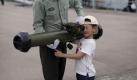 Ein chinesischer Soldat zeigt einem kleinen Jungen bei einem 'Tag der offenen Tür' in Hongkong eine Panzerfaust. Foto: Jerome Favre Foto: dpa