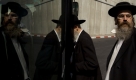Ultra Orthodox Jewish pilgrims get on a bus near by the concrete and wire barrier built by Israel to secure the Rachel's Tomb Judaism's third holiest shrine, during an annual mass prayer that drew tens of thousands of worshippers to commemorate the Jewish Matriarch Rachel, in the west bank town of Bethlehem, Thursday Oct. 29, 2009. (AP Photo/Oded Balilty) Foto: ap