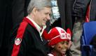 Der kanadische Premierminister Stephen Harper lässt sich mit dem achtjährigen Jaden Severy auf der Zuschauertribüne beim Sledge-Hockey fotografieren. Foto: ap