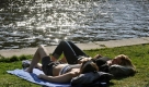 Zwei Frauen geniessen am Montag, 13. April 2009 in Berlin die Sonne am Spreeufer. Ein Hochdruckgebiet sorgt am Osterwochenende fuer Sonnenschein. (AP Photo/Gero Breloer) --- Residents enjoy the sun on the bank of Spree river in Berlin, Monday, April 13, 2009. (AP Photo/Gero Breloer) Foto: ap