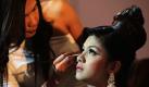 Ein Model lässt sich von einem philippinischen Haarstylisten und Make-Up-Künstler auf einem Modewettbewerb verschönern. Auf der Veranstaltung sollen neue Talente und Stile entdeckt werden. Außerdem wird die Arbeit eines Stylisten als legitimer Beruf präsentiert. Foto: dpa