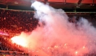 Istanbuls Fans zünden bengalische Feuer auf der Tribüne im Wolfsburger Stadion. Foto: dpa