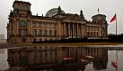 Der Berliner Reichstag spiegelt sich am Freitagmorgen in einer Pfütze. Die Meteorologen sagen für das Wochenende wieder etwas freundlicheres Wetter bei Temperaturen von bis zu zehn Grad voraus. Foto: dpa