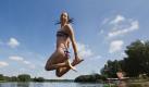 Studentin Katrin aus Allersberg springt am Rothsee nahe Polsdorf bei strahlendem Sonnenschein und blauem Himmel vom einem Steg ins Wasser.  Foto: dapd