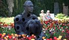 Besucher ruhen sich im Blumengarten der Bundesgartenschau am Deutschen Eck in Koblenz bei einem Beet mit Tulpen hinter der Bronzefigur Jaume Plensa Alchemy 2006 aus. Die BUGA endet am 16. Oktober 2011 und konnte über das sonnige Osterwochenende tausende Besucher begeistern. Foto: dapd