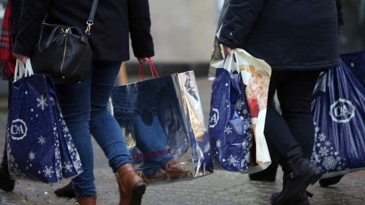 Passanten mit Taschen voller Weihnachtseinkäufe, unter anderem von CA, in der Fußgängerzone von Köln.
