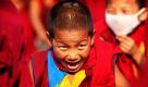Ein junger Buddhist lacht während einer Lesung des Dalai Lamas in Bodh Gaya, Indien. Foto: ap
