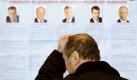 Die Qual der Wahl: Ein russischer Bürger in der Ukraine steht vor einem Plakat mit den Kandidaten der russischen Präsidentenwahl. Foto: Sergey Dolzhenko Foto: dpa