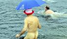 Ein nackter Mann steigt beim Neujahrsschwimmen in Berlin in das vier Grad kalte Wasser des Orankesees. Foto: Maurizio Gambarini Foto: dpa