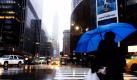 Eine Frau geht im regnerischen New York City über die Straße. In New York herrscht kein frühlingshaftes Wetter: Regen und sechs Grad Celsius. Foto: ap