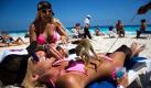 Ein Affe überrascht eine Urlauberin am Strand der mexikanischen Partyhochburg Cancún. Der karibische Urlaubsort erholt sich schnell von dem Imageschaden, der durch die Schweinegrippe und Kriminalität enstanden ist. Foto: ap