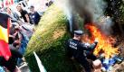 Ein Polizeibeamter versucht vor dem Justus-Lipsius-Gebäude in Brüssel, dem Sitz des Rates der Europäischen Union, ein Feuer auszutreten. Während sich im Gebäude die Landwirtschaftsminister der EU treffen, protestieren davor Milchbauern gegen die europäische Preispolitik. Foto: ap