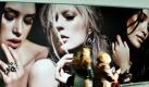 Besucher der Messe inhorgenta - Internationale Fachmesse für Schmuck, Uhren, Design, Edelsteine und Technologie - gehen  in München an einer grossen Werbetafel für Schmuck vorbei. Die Hersteller präsentieren noch bis Montag  die neuesten Trends der Branche - neben Uhren und Schmuck auch Edelsteine und Perlen. Foto: dpa