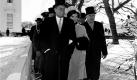 ** FILE ** In this Jan. 20, 1961 black-and-white file photo, President John F. Kennedy and Mrs. Kennedy walk outside the White House during inauguration ceremonies, just as the parade began. An 8-inch snowfall on the eve of John F. Kennedy's inauguration in 1961 left hundreds of cars marooned and thousands more abandoned. The president-elect had to cancel dinner plans and, in a struggle to keep other commitments, is reported to have had only 4 hours of sleep. An army of men worked all night to clear Pennsylvania Avenue, using flame-throwers. (AP Photo, File) Foto: ap
