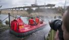 Ein Fotograf beobachtet am Mittwoch, 03. Maerz 2010, Rettungskraefte in einem Luftkissenfahrzeug auf dem Weg zur Baustelle der ICE-Bruecke nahe Halle, Sachsen-Anhalt. Auf der Baustelle entlang der ICE-Neubaustrecke Erfurt-Halle/Leipzig sind ein Kran und ein 1.000 Tonnen schweres Baugeruest abgestuerzt. Nach ersten Erkenntnissen wurden dabei mehrere Menschen zum Teil schwer verletzt. (apn Photo/Eckehard Schulz) ----- -----A photographer takes a picture of rescuers in a boat at the site of an accident along the railway tracks where several workers were injured near Halle, eastern Germany, Wednesday, March 3, 2010. (apn Photo/Eckehard Schulz) Foto: ap