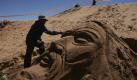 In Bolivien formt ein Mann das Gesicht Jesu Christi aus Sand. Foto: ap