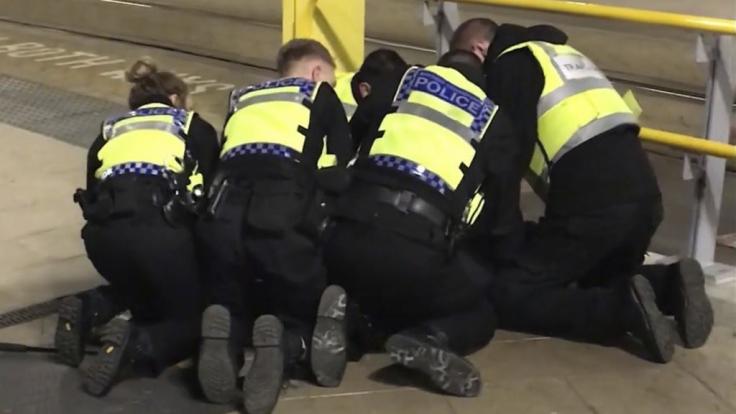 Polizisten halten am Bahnhof Victoria Station einen Mann am Boden, der zuvor drei Menschen mit einem Messer verletzt hatte.