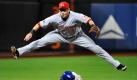 Zum Glück sind die Hosen des Baseballers Paul Janish reißfest. Mit einem akrobatischen Spagat fing der Spieler der Cincinnati Reds den Ball und kam damit seinem Gegenspieler Nick Evans von den New York Mets zuvor. Durch den missglückten Punkt verloren die Mets das Spiel mit 5:6. Foto: dapd