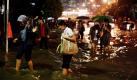 Angestellte waten in einem Büroviertel in Jakarta durch die Fluten. Nach schweren Regenfällen sind viele Straßen der indonesischen Hauptstadt überflutet. Foto: dapd
