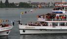 Der Kapitän des Passagierschiffs Schwaben aus Deutschland (rechts) überreicht auf dem Bodensee vor Friedrichshafen seinem Gegenüber auf der Schaffhausen aus der Schweiz eine Flasche Sekt. Sechs Schiffe unter den Flaggen der Schweiz, Österreichs und Deutschlands bildeten auf dem Bodensee einen Stern, um traditionell die neue Saison zu eroeffnen. Foto: dapd