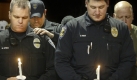 Black Diamond, Wash., Police Officer Brian Lynch, left, prays while Enumclaw police officers Dustin Lobdell, with hand on Lynch, and Tony Ryan, right foreground, during a vigil at Champions Centre in Tacoma, Wash., Sunday, Nov. 29, 2009. The event honored four Lakewood Police Officers ambushed and killed at a Forza Coffee Company in Parkland, Wash. Issaquah Police officer Robert Hendrickson is right rear. (AP Photo/The News Tribune, Dean J. Koepfler) Foto: ap