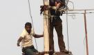 Keine Angst vor Spannung: Im indischen Chennai reparieren zwei Männer eine Hochspannungsleitung. Foto. Nathan G Foto: dpa
