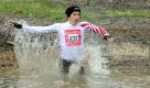 Am Fisherman's StrongmanRun auf dem Nürburgring nahmen an diesem Wochenende insgesamt 10940 Läufer teil. Im Bild ist Florian Neuschwander zu sehen. Der Sportler durchquert das Hindernis Fischernetz. Er siegte auf der zweimal 9,8 Kilometer langen Strecken nach 1:21:27 Stunden. Foto: dapd