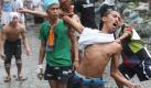 Voller Wut: Aufgebrachte Slumbewohner attackieren in Manila eine Abrissmannschaft. Foto: Dela Pena Foto: dpa
