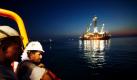 Arbeiter beobachten, wie eine Stahlkuppel an der Stelle ins Wasser gelassen wird, wo die Bohrinsel Deepwater Horizon gesunken ist. Die mehr als 100 Tonnen schwere Stahlkuppel soll 1500 Meter tief abgeseilt werden, um dann den Austritt des Öls kontrollierbar machen zu können. Foto: ap