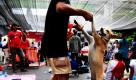 Ein regierungskritischer Anhänger der Rothemden tanzt mit seinem Hund in einem Demo-Camp in der thailändischen Hauptstadt Bangkok. Der Konflikt geht weiter: Die Rothemden haben den Shopping-Bezirk besetzt und diverse Luxushotels zum Schließen genötigt.  Foto: ap