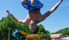 Ein junger Mann verschafft sich mit einem Salto ins Wasser des Freibades im brandenburgischen Neuzelle Abkühlung. Das Quecksilber stieg in Ostbrandenburg schon am Mittag auf 30 Grad Celsius.  Foto: dpa