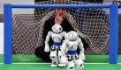 Magdeburg. Während der Roboter-Fussballmeisterschaft RoboCup German Open 2011 sitzt Tobias Kastner vom Weltmeisterteam B-Human Bremen hinter den zwei humanoiden Standardrobotern Nao im Tor des Spielfeldes. Rund 50 Teams aus 14 Ländern treten bis Sonntag bei den 10. RoboCup German Open gegeneinander an. Foto: dapd