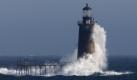 ** CORRECTS DAY TO THURSDAY ** Heavy surf slams into the 72-foot-tall Ram Island Ledge Light, Thursday, Dec. 3, 2009, at the mouth of Portland Harbor, in Portland, Maine. A quick moving storm with winds approaching 50 miles per hour brought record breaking warmth to Portland where the temperature reached 68 degrees. (AP Photo/Robert F. Bukaty) Foto: ap