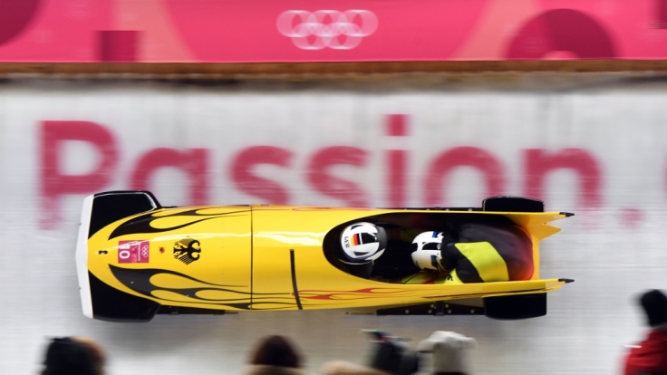 Die Bobpiloten stürzen sich den Eiskanal hinunter.