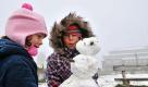 Den ersten Schneemann der Saison bauen die Dresdner Ferienkinder Sabrina (links) und Annalena auf dem 1215 Meter hohen Fichtelberg bei Oberwiesenthal (Sachsen). Während sich Wintersportler noch einige Tage gedulden müssen, ist die weiße Pracht für eine Schneeballschlacht oder einen Schneemann allemal ausreichend. Foto: dpa