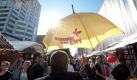 Ein Besucher des Kurfürstendamm-Sommerfestes Summer in the City hält am bei der Eröffnung des Straßenfestes in Berlin-Charlottenburg einen Regenschirm mit dem Logo des Festes nach oben. Das Straßenfest findet in diesem Jahr zum ersten Mal statt. Foto: dapd