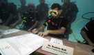 Der Minister für Fischerei und Landwirtschaft der Malediven, Ibrahim Didi, unterzeichnet einen Aufruf an alle Länder zur Kohlendioxidreduzierung - unter Wasser auf einer speziellen Unterwasserkonferenz des maledivischen Kabinetts. Diese soll das Problem der globalen Erwärmung besonders verdeutlichen. Foto: ap
