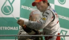 Der Dritte im Bunde in trauter Runde:Timo Glock versprht auf dem Podium in Sepang Champagner - auch Heidfeld im Hintergrung bekommt etwas ab. Foto: dpa