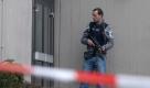 Ein Polizeibeamter mit einer Maschinenpistole wacht vor dem Schulgebäude. Foto: dpa