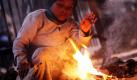 Ein obdachloser Junge in Neu Delhi wärmt sich an einem kleinen Feuer. Foto: dpa