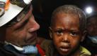 Ein spanischer Rettungsmitarbeiter trägt einen zweijährigen Jungen, der nach dem Erdbeben in Haiti unter Trümmern verschüttet geborgen wurde. Foto: ap