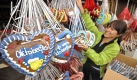 Verkäuferin Beate hängt auf der Theresienwiese in München (Bayern) einen Tag vor der Eröffnung des Oktoberfests 2009 Lebkuchenherzen an Annettes Herzerlstand auf. 
 Foto: dpa